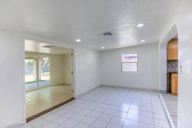 4842 E 27th St, Tucson, AZ 85711 - empty room with light tile patterned floors, recessed lighting, arched walkways, and baseboards