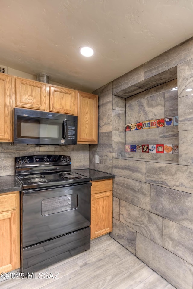 4842 E 27th St, Tucson, AZ 85711 - kitchen featuring black appliances, dark countertops, and light wood-style floors
