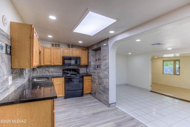 4842 E 27th St, Tucson, AZ 85711 - kitchen featuring black appliances, a sink, arched walkways, dark stone countertops, and backsplash