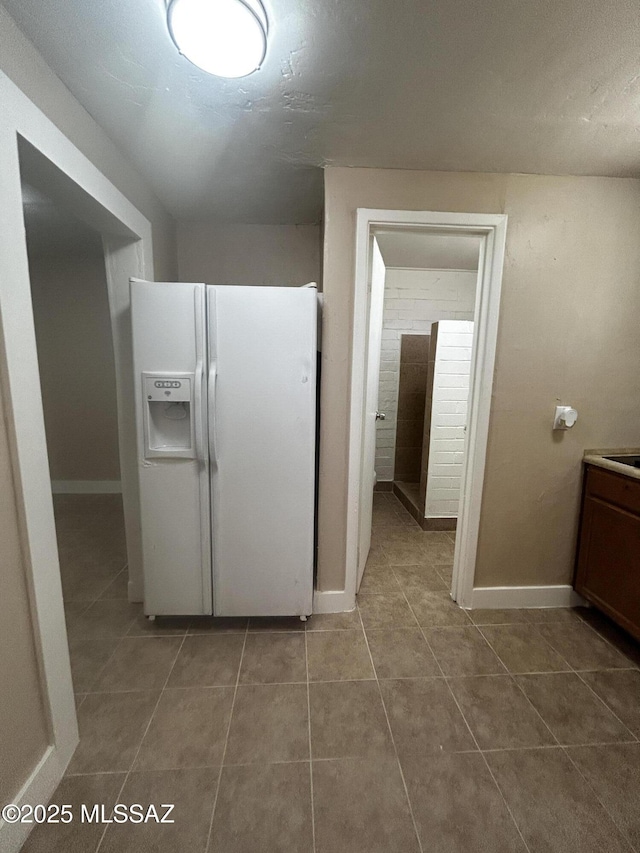 139 E 35th St, Tucson, AZ 85713 - kitchen featuring white refrigerator with ice dispenser, tile patterned floors, and baseboards