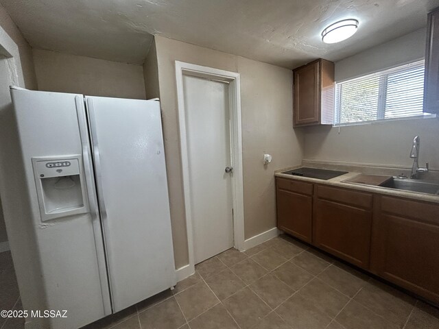 139 E 35th St, Tucson, AZ 85713 - kitchen featuring white fridge with ice dispenser, a sink, light tile patterned flooring, and light countertops