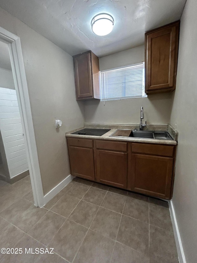 139 E 35th St, Tucson, AZ 85713 - kitchen with a sink, baseboards, light tile patterned flooring, and light countertops