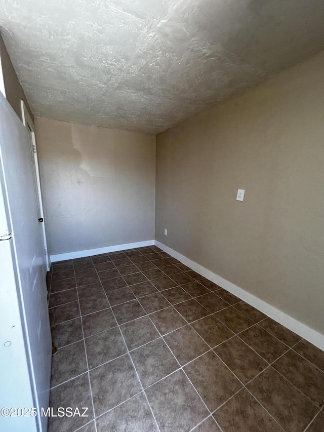 139 E 35th St, Tucson, AZ 85713 - unfurnished room featuring dark tile patterned flooring, a textured ceiling, and baseboards
