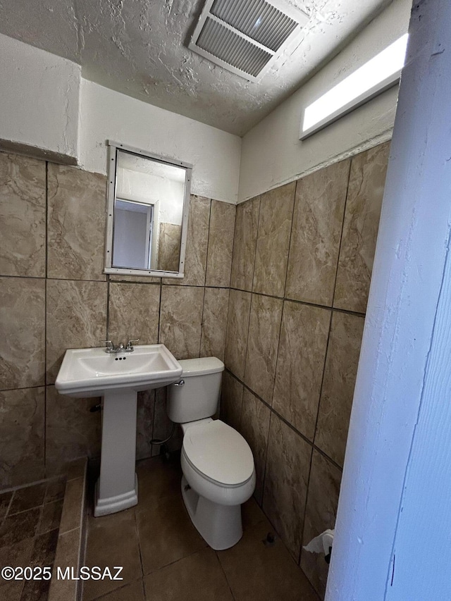 139 E 35th St, Tucson, AZ 85713 - half bathroom featuring toilet, tile walls, and tile patterned flooring