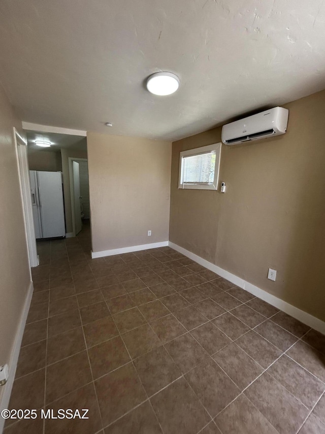 139 E 35th St, Tucson, AZ 85713 - empty room featuring an AC wall unit, dark tile patterned floors, and baseboards