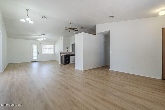 1741 W Maplewood Dr, Tucson, AZ 85746 - unfurnished living room featuring vaulted ceiling, a ceiling fan, light wood-type flooring, baseboards, and a chandelier
