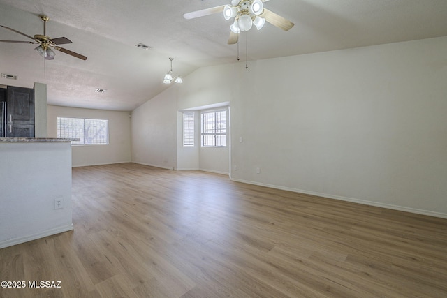 1741 W Maplewood Dr, Tucson, AZ 85746 - unfurnished living room featuring ceiling fan, lofted ceiling, light wood-style floors, and baseboards