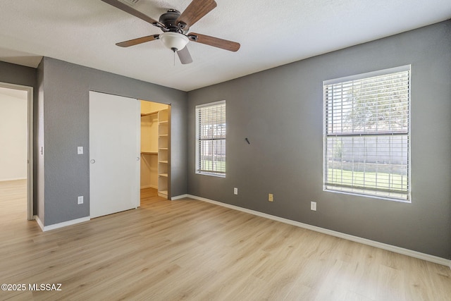 1741 W Maplewood Dr, Tucson, AZ 85746 - unfurnished bedroom with light wood finished floors, multiple windows, and baseboards