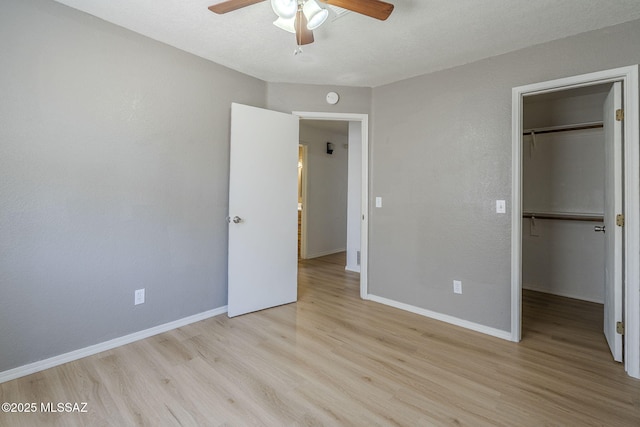 1741 W Maplewood Dr, Tucson, AZ 85746 - unfurnished bedroom featuring wood finished floors, a walk in closet, and baseboards