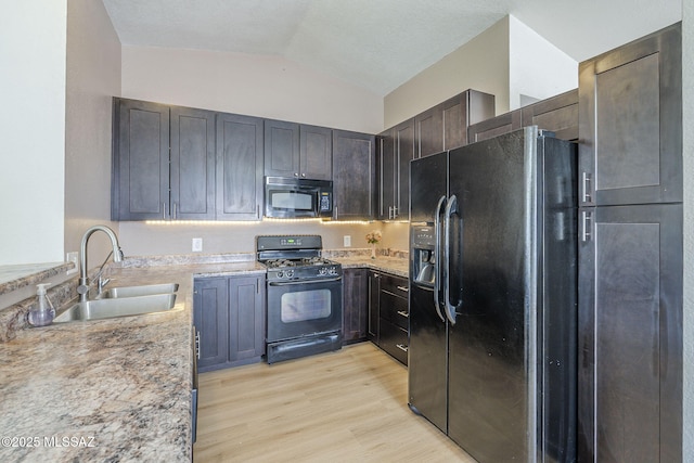 1741 W Maplewood Dr, Tucson, AZ 85746 - kitchen featuring black appliances, a sink, light wood-style floors, lofted ceiling, and light stone counters