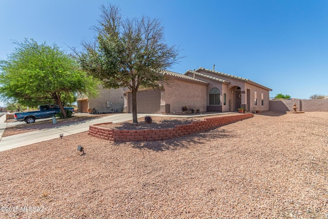 5608 Shady Grove, Tucson, AZ 85742 - rear view of property featuring a garage, concrete driveway, fence, and stucco siding