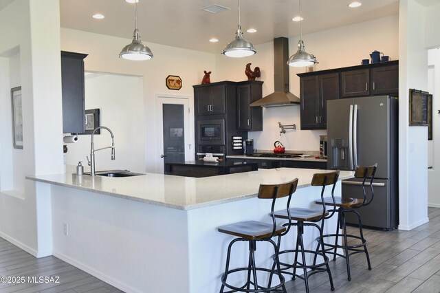 8867 S Welsh Pl, Hereford, AZ 85615 - kitchen featuring stainless steel refrigerator with ice dispenser, wall chimney exhaust hood, a sink, oven, and light wood-type flooring