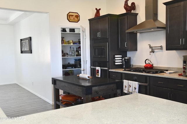 8867 S Welsh Pl, Hereford, AZ 85615 - kitchen with wall chimney range hood, black appliances, light countertops, wood finished floors, and baseboards