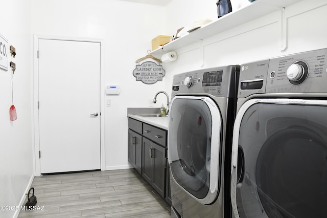 8867 S Welsh Pl, Hereford, AZ 85615 - clothes washing area featuring washer and clothes dryer, cabinet space, baseboards, and light wood-type flooring