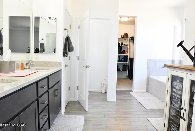 8867 S Welsh Pl, Hereford, AZ 85615 - bathroom with wood finished floors, wine cooler, a spacious closet, a bath, and double vanity