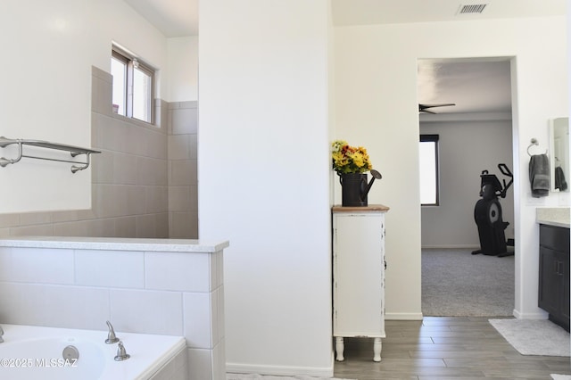 8867 S Welsh Pl, Hereford, AZ 85615 - full bath with a garden tub, vanity, wood finished floors, baseboards, and ceiling fan