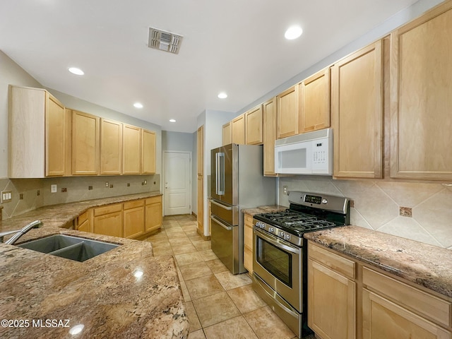 13401 N Rancho Vistoso Blvd Unit 190, Oro Valley, AZ 85755 - kitchen featuring appliances with stainless steel finishes, light brown cabinets, a sink, tasteful backsplash, and light stone counters