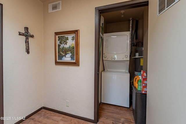 413 N Calle Del Diablo, Green Valley, AZ 85614 - laundry room with stacked washing machine and dryer, wood finished floors, baseboards, and secured water heater