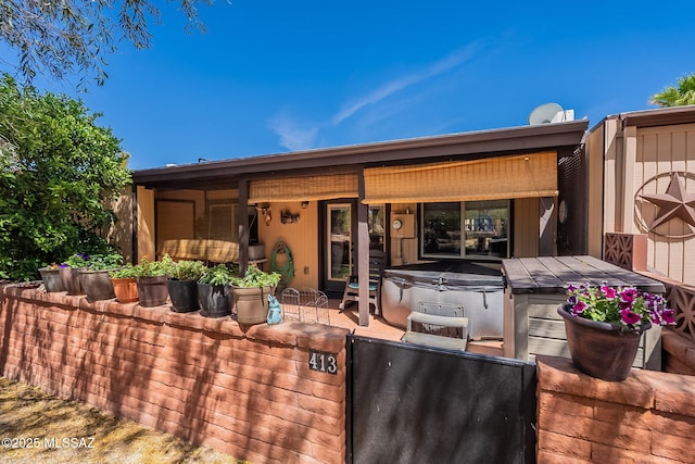 413 N Calle Del Diablo, Green Valley, AZ 85614 - back of house featuring a hot tub, fence, and a gate