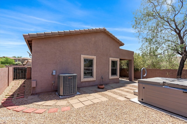 45 N Lookout Knob Dr, Sahuarita, AZ 85629 - back of house featuring central air condition unit, a hot tub, a fenced backyard, and stucco siding