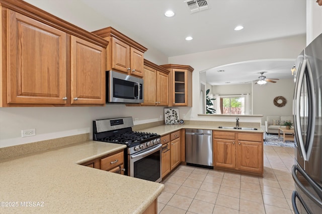 45 N Lookout Knob Dr, Sahuarita, AZ 85629 - kitchen featuring appliances with stainless steel finishes, a peninsula, light countertops, brown cabinets, and recessed lighting
