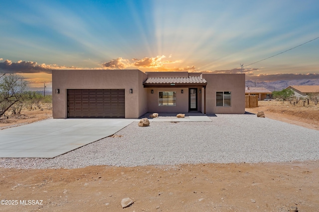 1814 Cajeme Ct, Rio Rico, AZ 85648 - pueblo revival-style home with an attached garage, stucco siding, concrete driveway, and a tiled roof