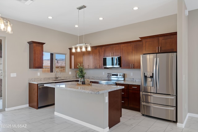 1814 Cajeme Ct, Rio Rico, AZ 85648 - kitchen featuring appliances with stainless steel finishes, a sink, a center island, light marble finish flooring, and decorative light fixtures
