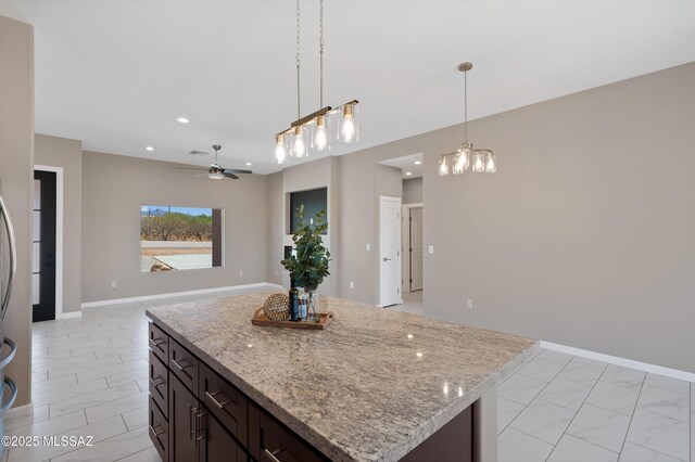 1814 Cajeme Ct, Rio Rico, AZ 85648 - kitchen featuring hanging light fixtures, light marble finish floors, a ceiling fan, light stone counters, and recessed lighting