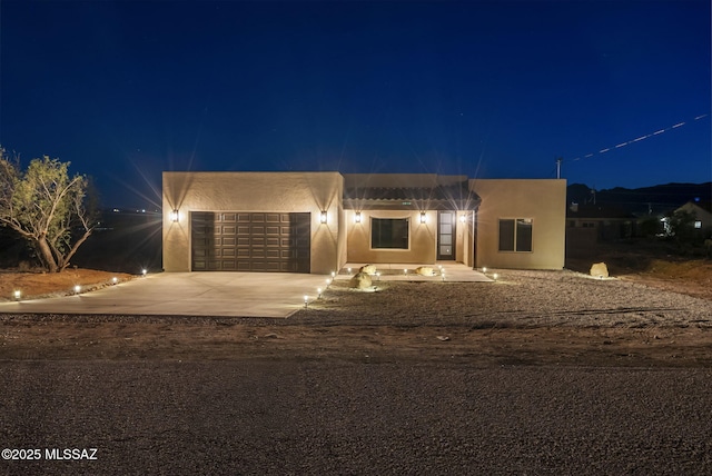 1814 Cajeme Ct, Rio Rico, AZ 85648 - pueblo-style house with driveway, an attached garage, and stucco siding
