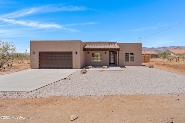1814 Cajeme Ct, Rio Rico, AZ 85648 - pueblo revival-style home with a garage, stucco siding, driveway, and a mountain view