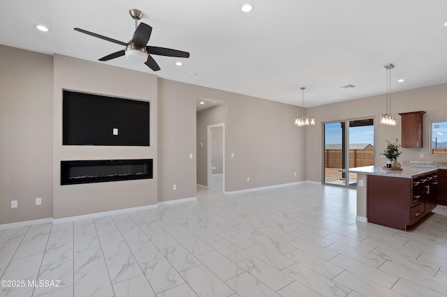 1814 Cajeme Ct, Rio Rico, AZ 85648 - kitchen featuring open floor plan, ceiling fan, a glass covered fireplace, light marble finish flooring, and recessed lighting