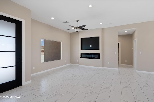 1814 Cajeme Ct, Rio Rico, AZ 85648 - unfurnished living room featuring light marble finish flooring, recessed lighting, a ceiling fan, a glass covered fireplace, and baseboards