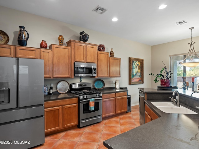 380 E Via Puente De La Lluvia, Sahuarita, AZ 85629 - kitchen featuring appliances with stainless steel finishes, a sink, dark countertops, brown cabinets, and recessed lighting