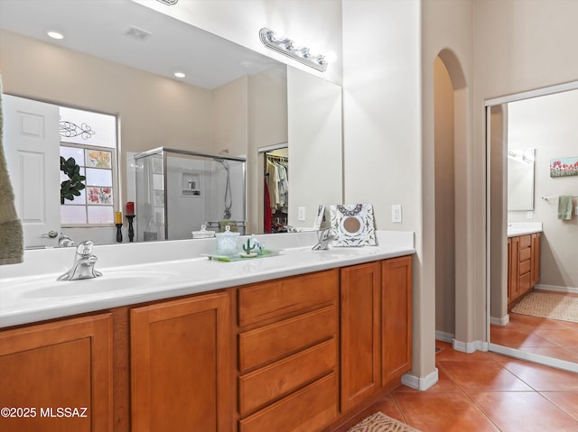 380 E Via Puente De La Lluvia, Sahuarita, AZ 85629 - full bath featuring double vanity, a stall shower, tile patterned flooring, and a walk in closet