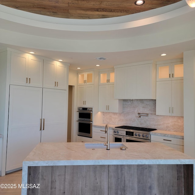 14295 N Silent Sky Pl, Marana, AZ 85658 - kitchen with stainless steel appliances, recessed lighting, light countertops, white cabinets, and glass insert cabinets