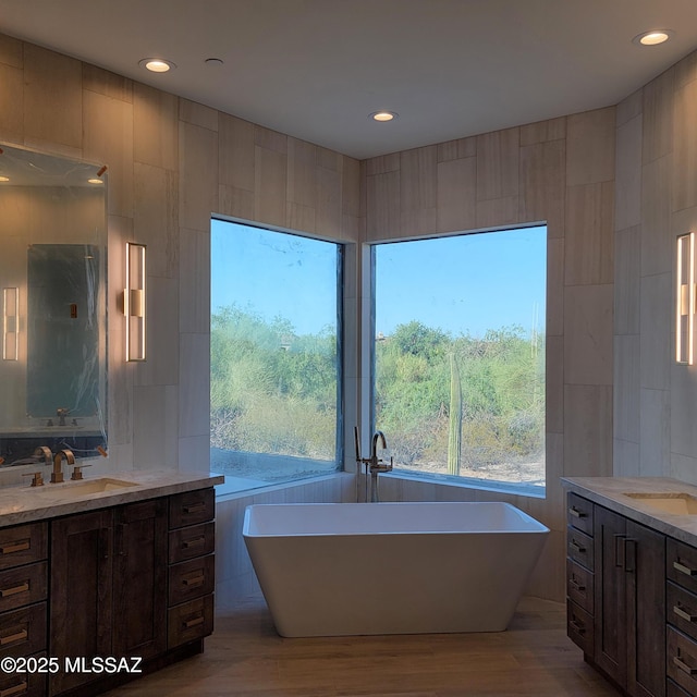 14295 N Silent Sky Pl, Marana, AZ 85658 - full bath with two vanities, a freestanding tub, wood finished floors, and recessed lighting