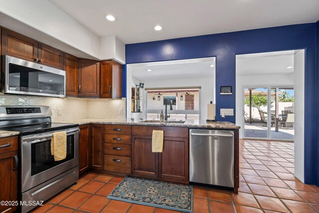2302 N Norton Ave, Tucson, AZ 85719 - kitchen with stainless steel appliances, a sink, decorative backsplash, tile patterned floors, and recessed lighting