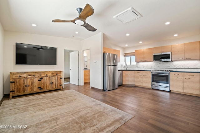 2302 N Norton Ave, Tucson, AZ 85719 - kitchen with stainless steel appliances, light brown cabinetry, tasteful backsplash, dark wood-type flooring, and dark countertops
