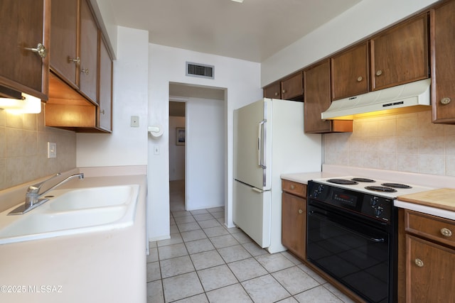 201 N Cloverland Ave, Tucson, AZ 85711 - kitchen featuring black range with electric cooktop, under cabinet range hood, light countertops, light tile patterned floors, and decorative backsplash