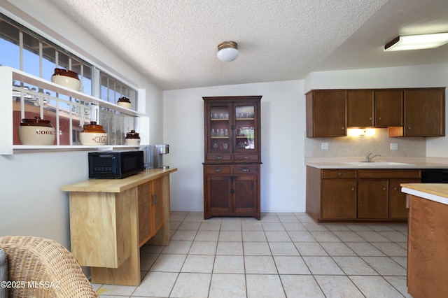 201 N Cloverland Ave, Tucson, AZ 85711 - kitchen featuring black appliances, a sink, a textured ceiling, decorative backsplash, and light tile patterned floors