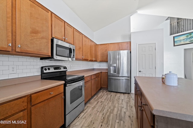 139 W Cheevers St, Vail, AZ 85641 - kitchen featuring appliances with stainless steel finishes, light wood finished floors, backsplash, brown cabinets, and high vaulted ceiling