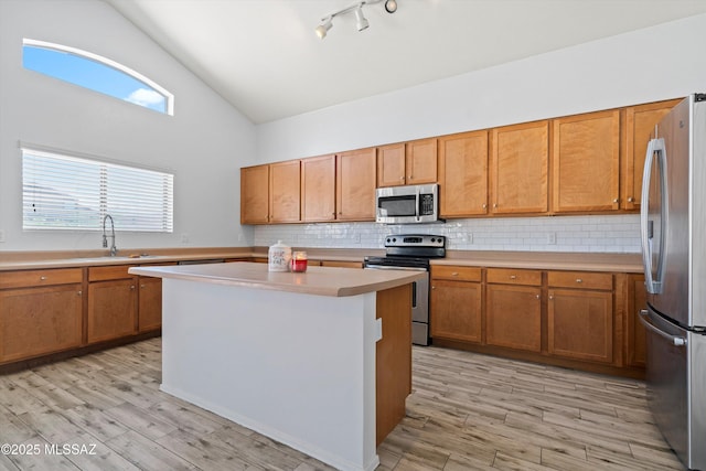 139 W Cheevers St, Vail, AZ 85641 - kitchen featuring stainless steel appliances, a sink, brown cabinetry, light countertops, and high vaulted ceiling