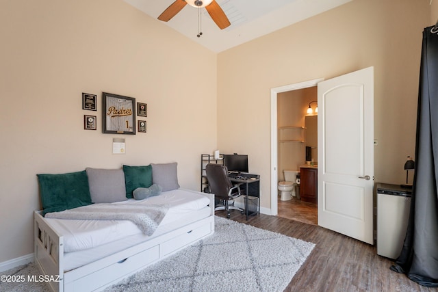 13715 N Tessali Way, Tucson, AZ 85755 - bedroom featuring wood finished floors, connected bathroom, a desk, baseboards, and high vaulted ceiling