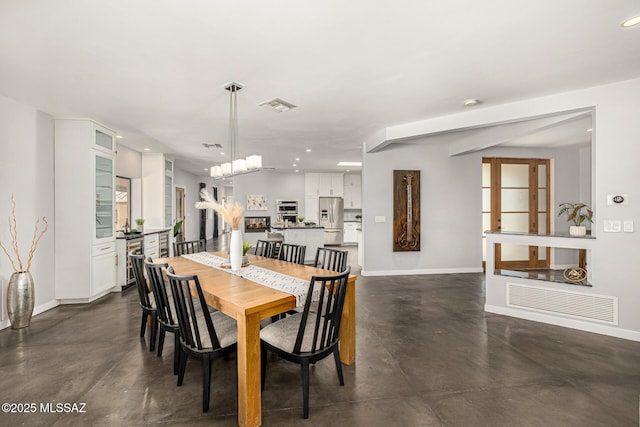 9840 N Desert Sky Rd, Tucson, AZ 85737 - dining area featuring baseboards, finished concrete floors, recessed lighting, and a chandelier