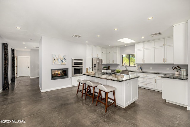 9840 N Desert Sky Rd, Tucson, AZ 85737 - kitchen featuring stainless steel appliances, recessed lighting, a center island, white cabinetry, and baseboards