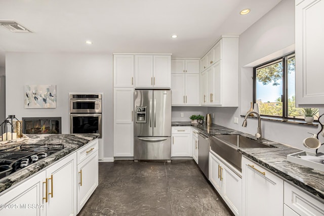 9840 N Desert Sky Rd, Tucson, AZ 85737 - kitchen featuring stainless steel appliances, a sink, white cabinets, recessed lighting, and dark stone counters