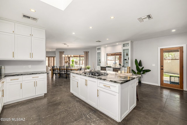 9840 N Desert Sky Rd, Tucson, AZ 85737 - kitchen featuring recessed lighting, stainless steel gas stovetop, white cabinetry, dark stone countertops, and a center island