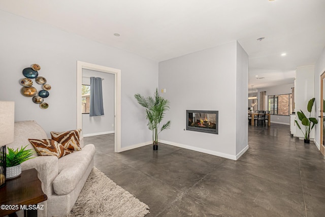 9840 N Desert Sky Rd, Tucson, AZ 85737 - living area with concrete flooring, baseboards, a multi sided fireplace, and recessed lighting