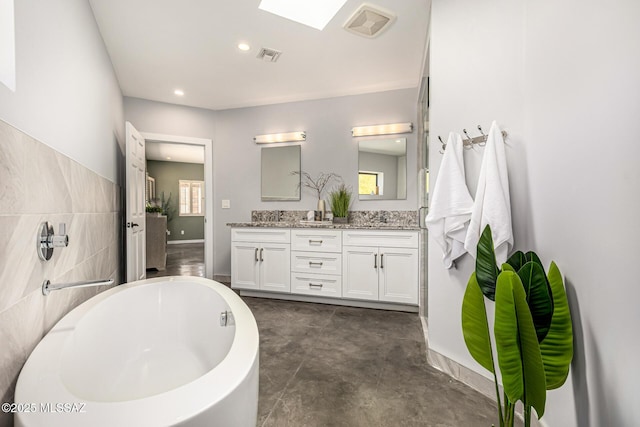 9840 N Desert Sky Rd, Tucson, AZ 85737 - full bath featuring double vanity, a freestanding bath, recessed lighting, and baseboards