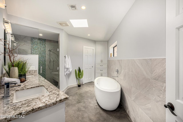 9840 N Desert Sky Rd, Tucson, AZ 85737 - bathroom featuring vanity, a shower stall, a freestanding bath, tile walls, and recessed lighting
